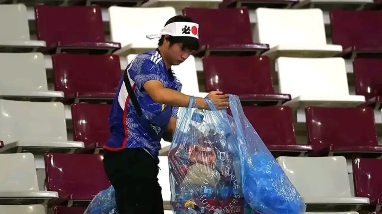 Des supporters japonais nettoient le stade après le match du Japon face à l'Allemagne